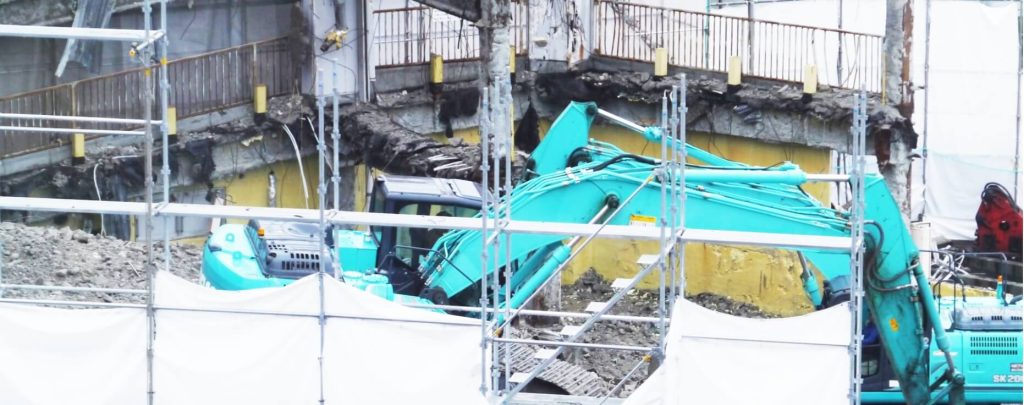 ブルドーザーが内装解体工事をしている写真