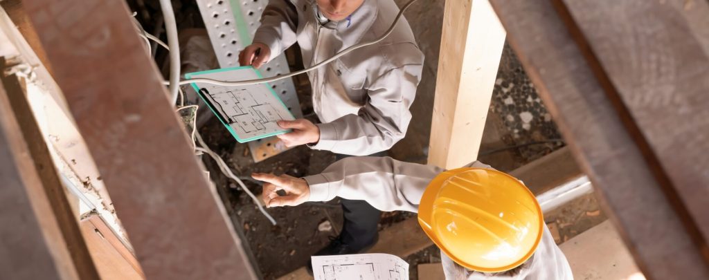 工事現場で作業服を着た2人の男性が議論している様子